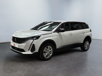 Un SUV blanc est garé dans une pièce au sol gris.