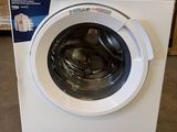 white washing machine in a store with boxes and boxes in the background