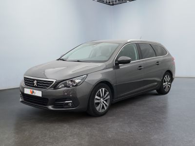 a grey car is parked in a room with a white wall