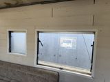 a couch in the corner of a room with three windows