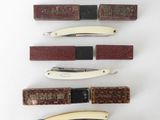 several different types of knives are lined up on a white surface