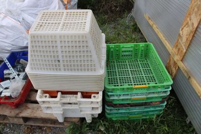 many plastic containers sitting on a pallet in the yard