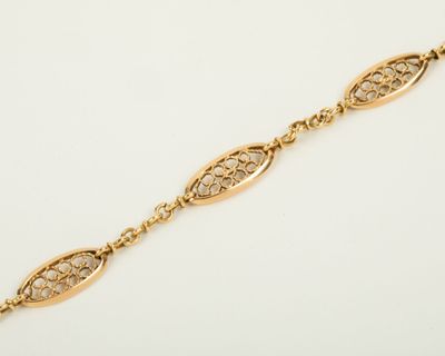 a gold bracelet with an intricate design on it