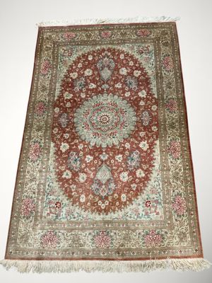 un tapis rouge orné d'un motif en médaillon et de franges