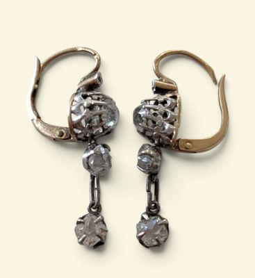 une paire de boucles d'oreilles anciennes en argent et diamants sur fond blanc