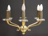 a gold chandelier with three candles on each of it
