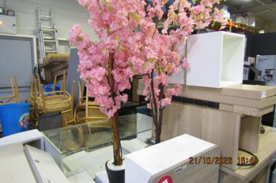 un vase contenant des fleurs roses, posé sur une table