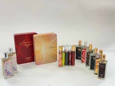 un assortiment de flacons de parfum et une boîte posés sur une surface blanche