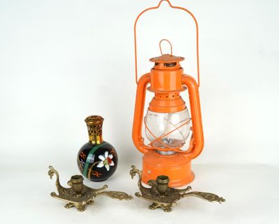 une lanterne orange posée à côté d'un vase sur une table
