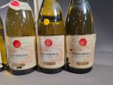 four bottles of wine are lined up on a table