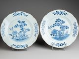 pair of blue and white plates with flowers and birds on them