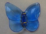 a blue glass butterfly sitting on a table