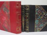 two red and black books sitting next to each other on a white surface
