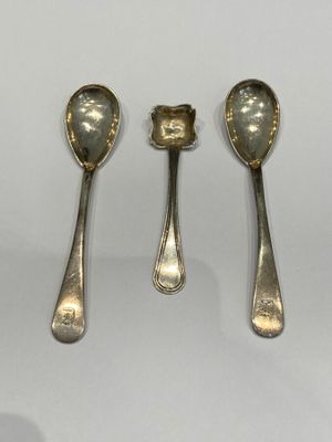 three silver spoons and two silver spoons on a white surface