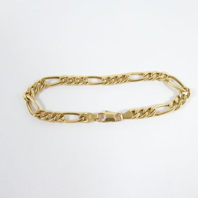a close up of a gold chain bracelet on a white surface