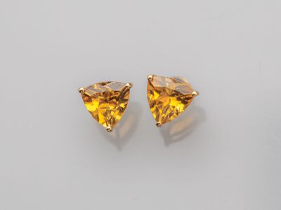 une paire de boucles d'oreilles en saphir jaune posées sur un fond blanc