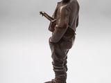 bronze figurine of a man with a hat playing a guitar