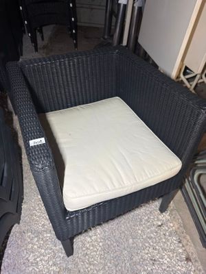 a wicker chair with a cushion on it in a room