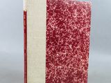 un livre rouge et blanc posé sur une table blanche