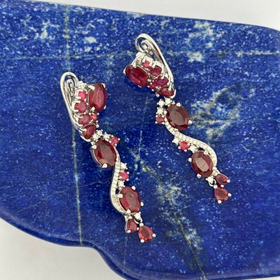 pair of ruby and diamond earrings on a blue stone slab