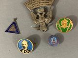 plusieurs pin's et badges différents posés sur une table