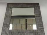 miroir rectangulaire dont le cadre est orné d'un motif noir et blanc