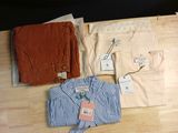three shirts and a tie on a wooden table