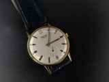 a close up of a watch on a black surface