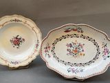 two plates with floral designs on them are sitting on a table