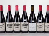 six bottles of wine lined up in a row on a table