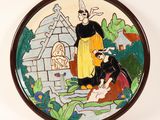 a plate with a painting of a woman and a man