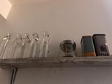 a shelf that has a bunch of empty wine glasses on it