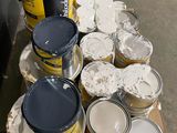 several cans of paint are sitting on a pallet in front of a wall