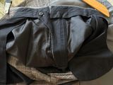 a pile of clothes and a wooden tie on a bed