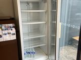 an empty refrigerator in the corner of a store