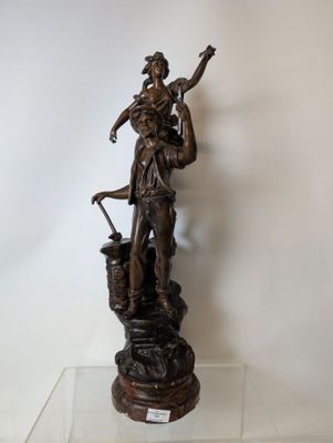 bronze statue of a woman holding a basket and a bird on a pedestal
