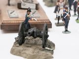 many figurines of soldiers on display on a white surface