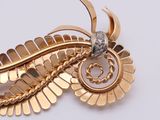 a close up of a gold brooch with a diamond on it