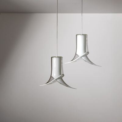 two glass lamps hanging from the ceiling in a white room