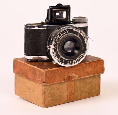 un vieil appareil photo posé sur une pile de cartons