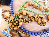 de nombreuses perles de différentes couleurs posées sur une table, avec une croix