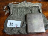 a silver purse with a chain around it on a table