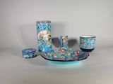 un vase bleu avec un bol et des tasses posés sur une table