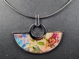 a close up of a necklace with a flower design on it