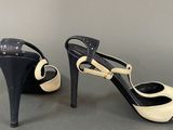 a pair of black and white high heeled shoes on a table