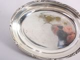 a silver plate with a reflection of a person in it