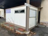 a small white building with a sign on the side of it