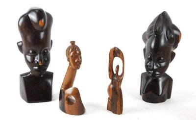 trois figurines en bois de formes et de tailles différentes posées sur une surface blanche