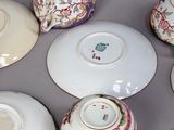 six tea cups and a saucer on a table