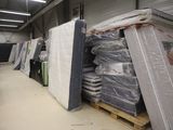 de nombreux matelas empilés sur des palettes dans un entrepôt